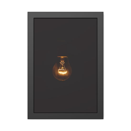 A glowing incandescent lightbulb illuminates a dark setting, symbolizing energy and innovation.