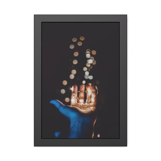 A close-up of a hand holding glowing string lights with a beautiful bokeh effect in the background.