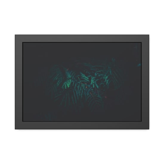 Dark and moody image of green fern leaves in natural light, creating a mysterious atmosphere.
