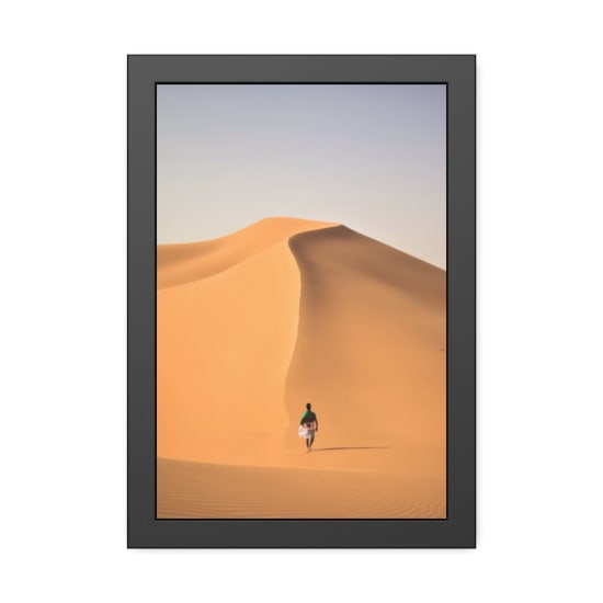 A lone traveler walking over the vast, golden sand dunes of the Sahara Desert in Algeria.