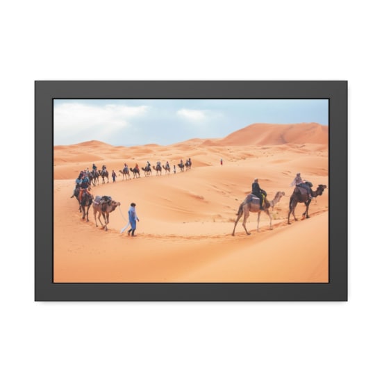 Tourists ride camels across the scenic sand dunes of Merzouga, Morocco.