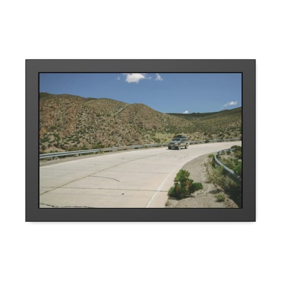 SUV driving on a winding mountain road in Jujuy, Argentina under a clear blue sky.