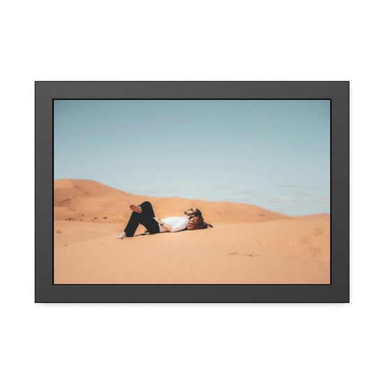 A man enjoys a peaceful moment lying on the sand dunes in the Al Wahat Al Dakhla Desert, Egypt.