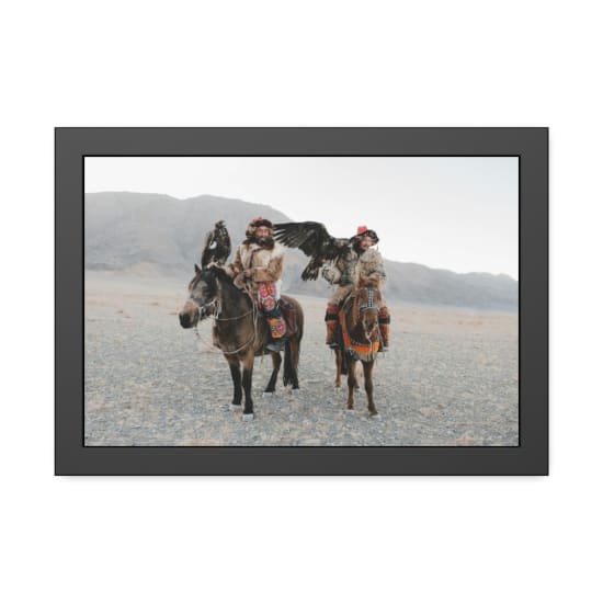 Mongolian eagle hunters on horseback in traditional attire, showcasing vibrant culture.