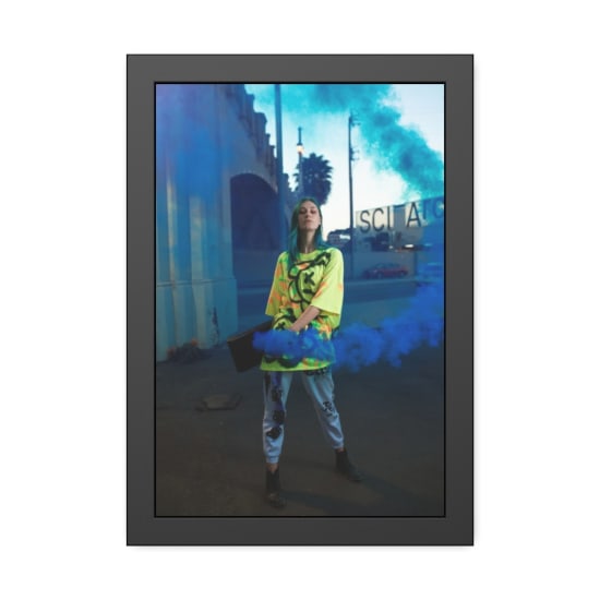 A fashion-forward individual in vibrant street style amidst colorful smoke outdoors.