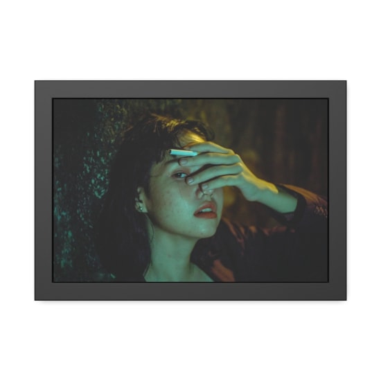 Dramatic portrait of a woman in low light, expressing emotion and contemplation.