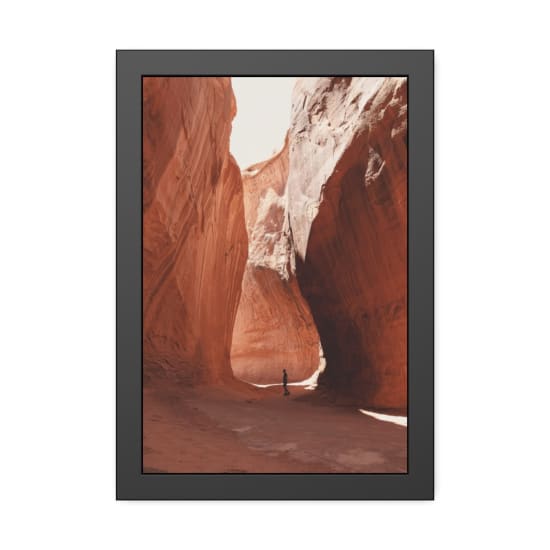 A solitary hiker walks through the stunning rock formations of a canyon near Lake Powell, Utah.