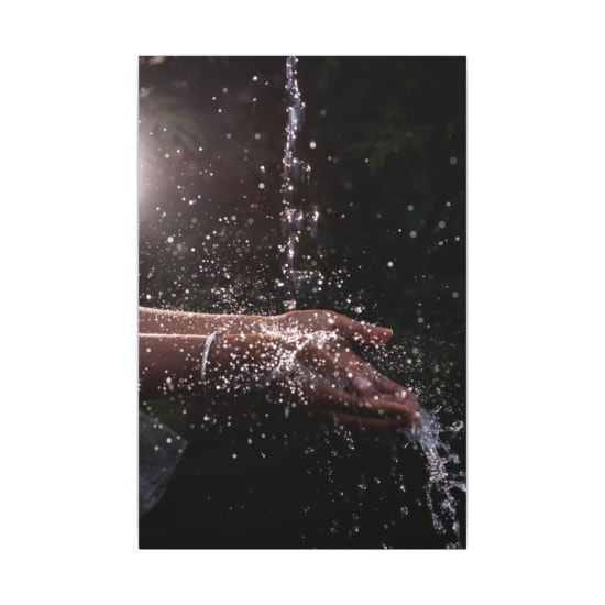 A vivid close-up of water splashing over cupped hands, capturing the essence of freshness and purity.