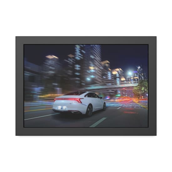 White sedan speeding through a vibrant, neon-lit city street at night capturing urban energy.