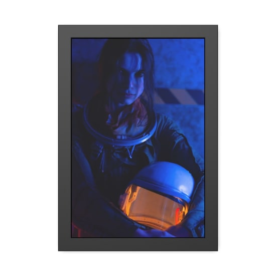 A woman in a spacesuit holds her helmet, highlighted by blue lighting, creating a sci-fi feel.
