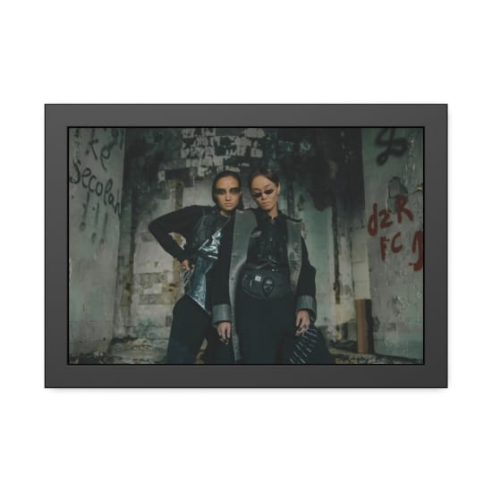 Two models in futuristic attire posing in an urban dystopian setting with graffiti.