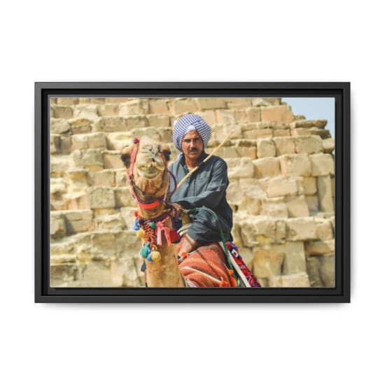 A Bedouin man rides a camel in front of the pyramids in Giza, Egypt.