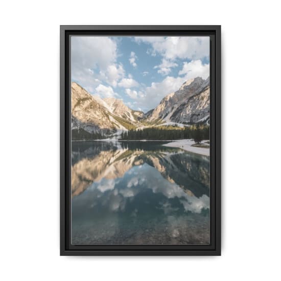 Scenic view of a serene lake with mountain reflections in the Dolomites, Italy.