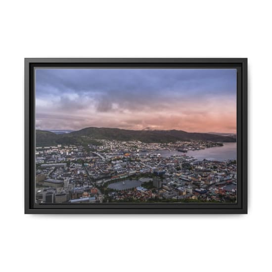 A captivating aerial shot of Bergen, Norway at dusk showcasing the cityscape, harbor, and surrounding mountains.