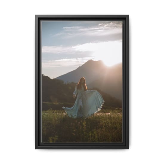 A serene image of a woman in a flowing blue dress with mountains in the sunset background.