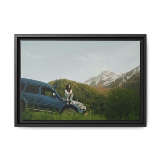 A woman sitting on an SUV with scenic mountain views. Perfect for travel and adventure themes.