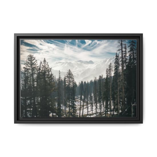 Breathtaking view of snow-capped mountains and pine trees in a winter landscape under a clear sky.