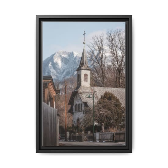 A rustic church set against a snowy mountain backdrop, exuding tranquility and charm.