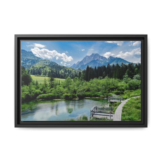 Beautiful view of mountains, forest, and lake with wooden walkway.