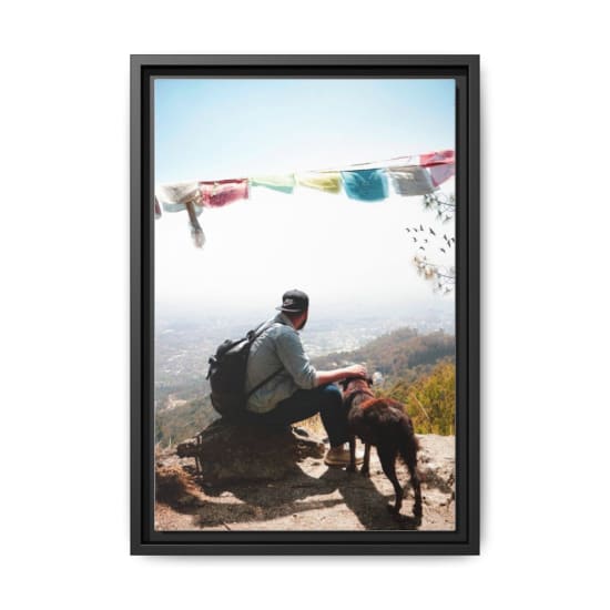 A man with his dog enjoying a scenic view over the Himalayas in Nepal.