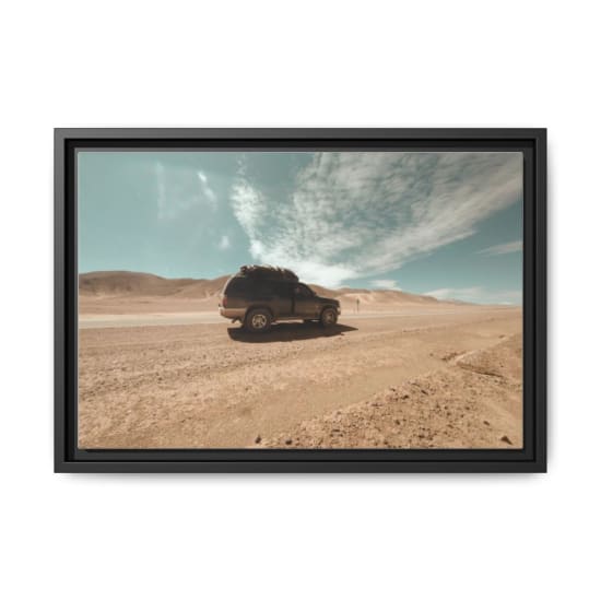 An SUV travels through an arid desert landscape on a sunny day.