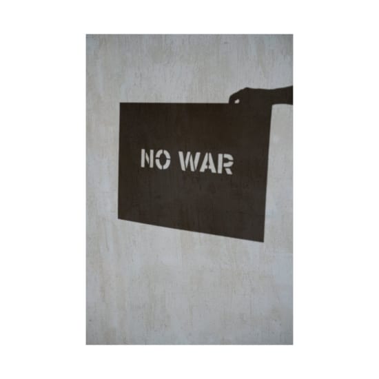 Shadow art depicting 'No War' message on a textured concrete wall, emphasizing peace.