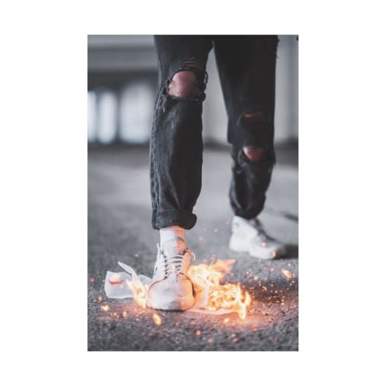 Stylish sneakers ignited in flames highlight urban fashion and daring style.