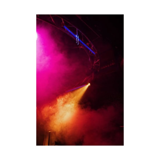 Colorful nightclub scene with vibrant lighting and smoke creating an energetic party vibe.