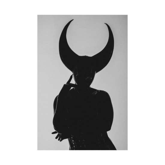 Black and white silhouette of a person with large horns in a striking studio pose.