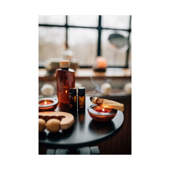 A calming indoor aromatherapy scene featuring candles, bottles, and burning Palo Santo, perfect for relaxation.