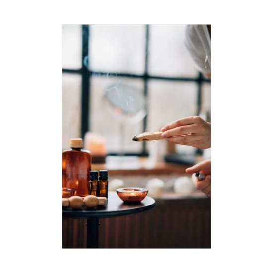 A soothing aromatherapy setup featuring burning sage and a lit candle for relaxation.