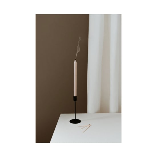 Minimalist scene with an extinguished candle emitting a wisp of smoke