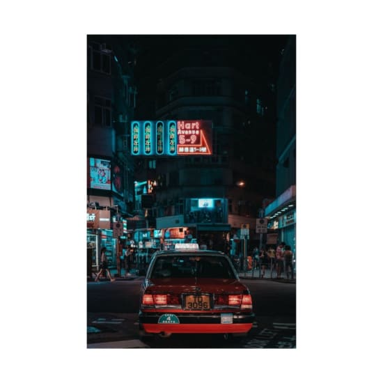 Vibrant nighttime street view in Kowloon, Hong Kong, featuring neon signs and a taxi.
