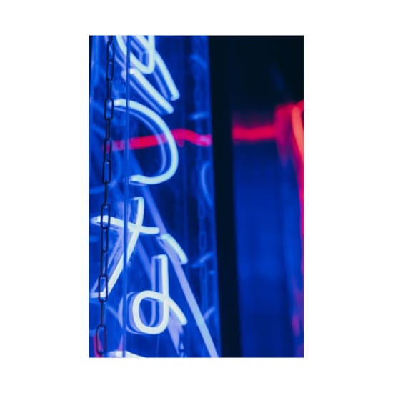 Close-up shot of a glowing blue and red neon sign, creating an artistic and vibrant atmosphere.