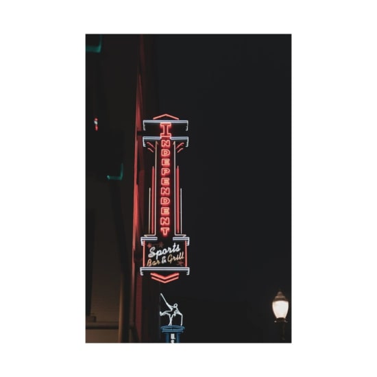 Vibrant neon sign for the Independent Sports Bar & Grill at night.