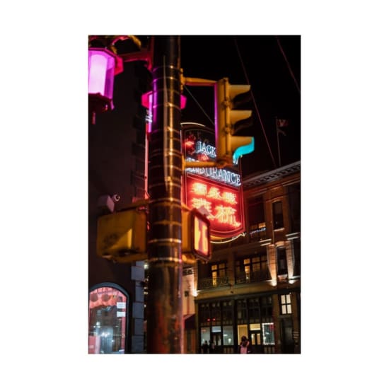 Vibrant neon city street scene with illuminated traffic lights and signs at night in an urban setting.