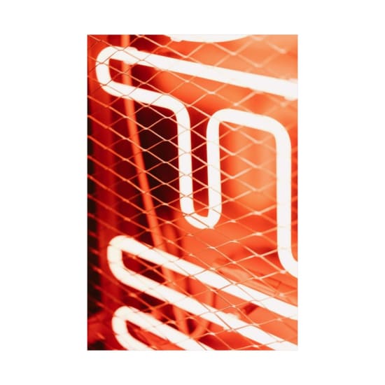 Close-up of an orange neon light behind wire mesh, creating an abstract and illuminated display.