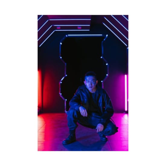 Asian man in a cyberpunk setting with neon lights, exuding a cool futuristic style.