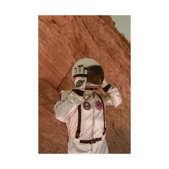 A futuristic scene of an astronaut exploring an alien desert landscape in full gear.