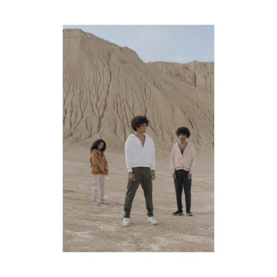 Stylish models pose in a unique desert landscape wearing modern fashion attire. Captivating earthy tones and casual styles.