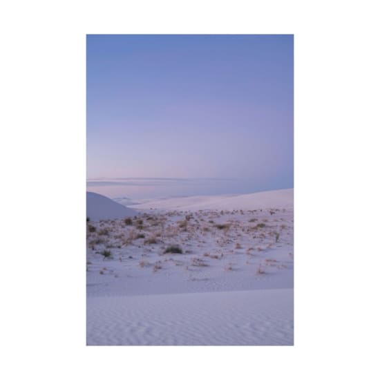 White sand dunes at dawn create a serene desert landscape with pastel skies.