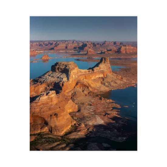 Stunning aerial view of Utah's breathtaking canyon landscape with a scenic lake at sunset.