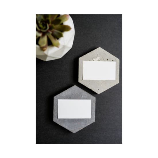 Elegant flatlay of blank business cards on hexagonal concrete slabs with succulent.
