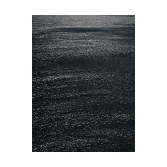 A calm and dark ocean surface reflecting intricate textures under moonlight. Peaceful and serene.