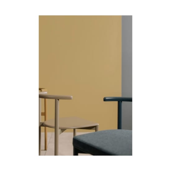 A minimalist arrangement of chairs with a colorful wall background, ideal for modern interior decor.