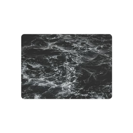 Monochrome image of turbulent ocean waves showing intricate textures and movement.