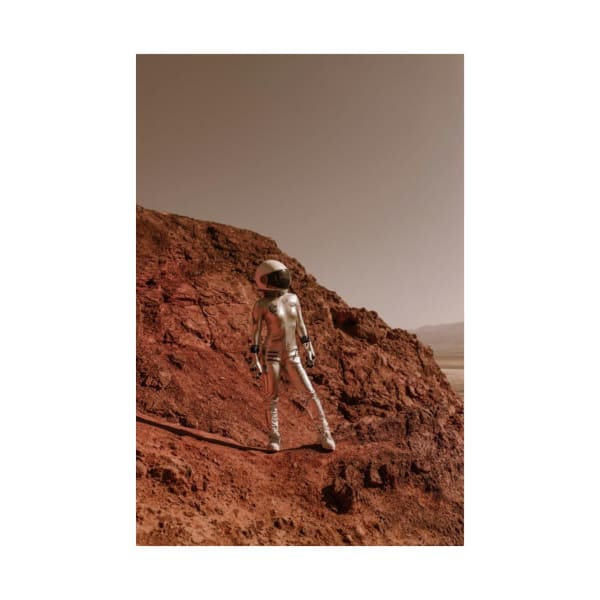 Female astronaut in silver spacesuit explores rocky alien terrain, evoking interplanetary adventure.