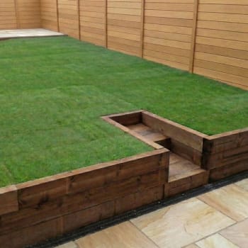 brown treated garden railway sleeper retaining wall