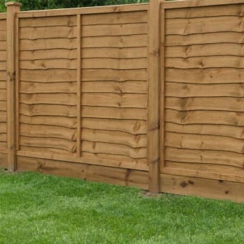 brown treated timber gravel board in a fence