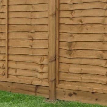 brown treated wooden fence post in a fence